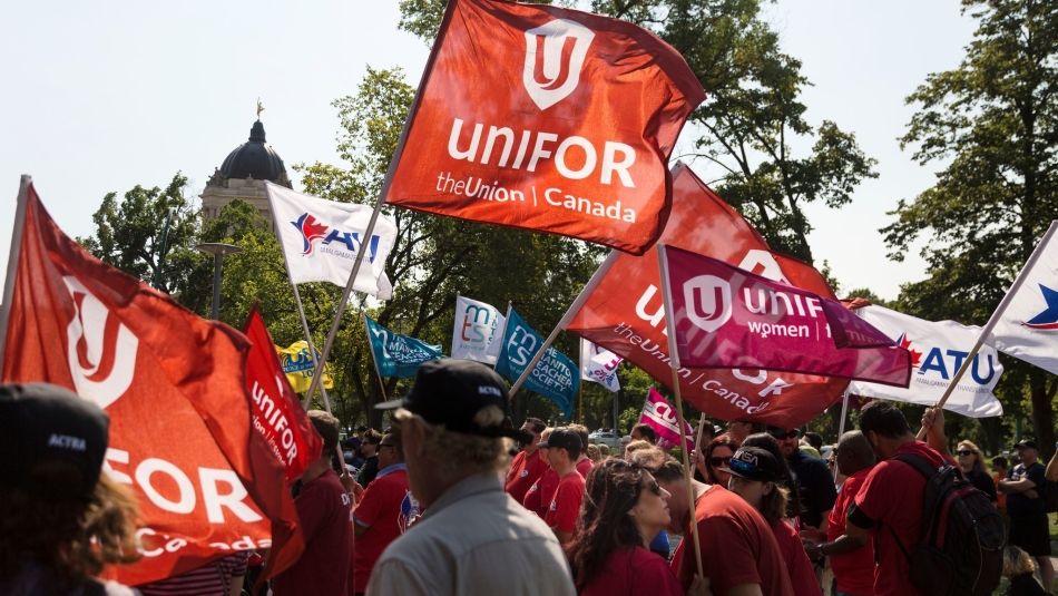 Unifor flags held up into the sky.