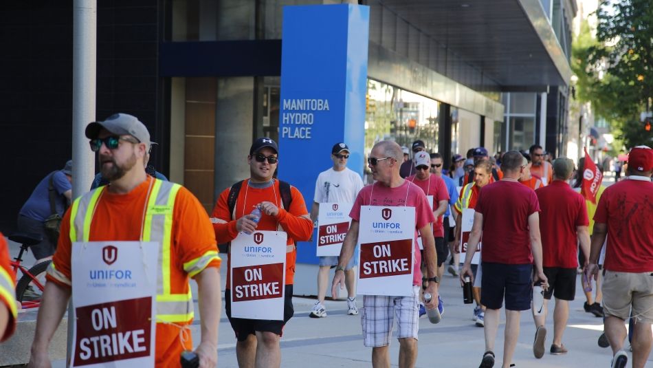 Membres de la section locale 681 d'Unifor marchant avec des pancartes de grève