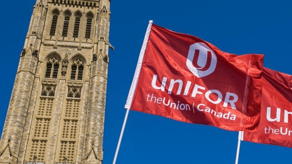 Drapeau d'Unifor flottant devant la Colline du Parlement.