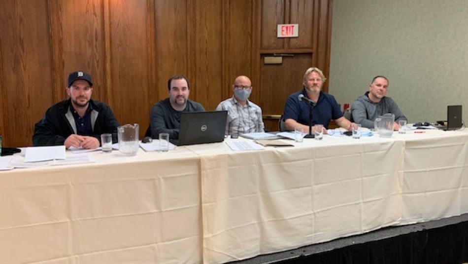 Five people posing for a photo at a long table