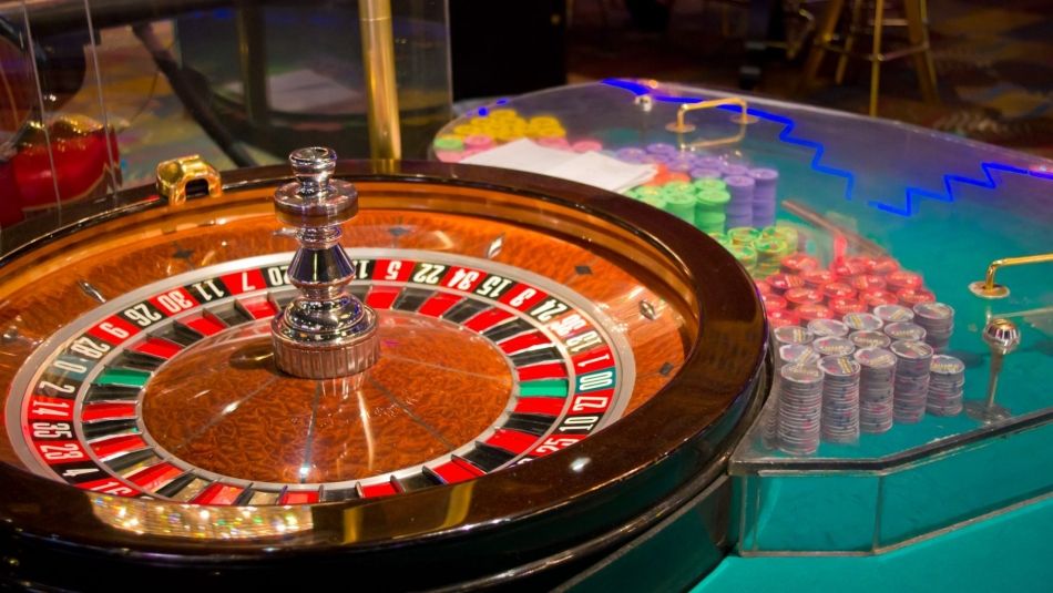 Roulette wheel beside stacks of poker chips