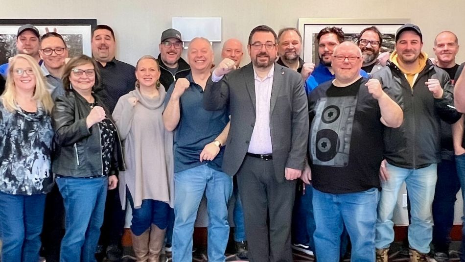 Daniel Cloutier posing with members holding their fists in the air.