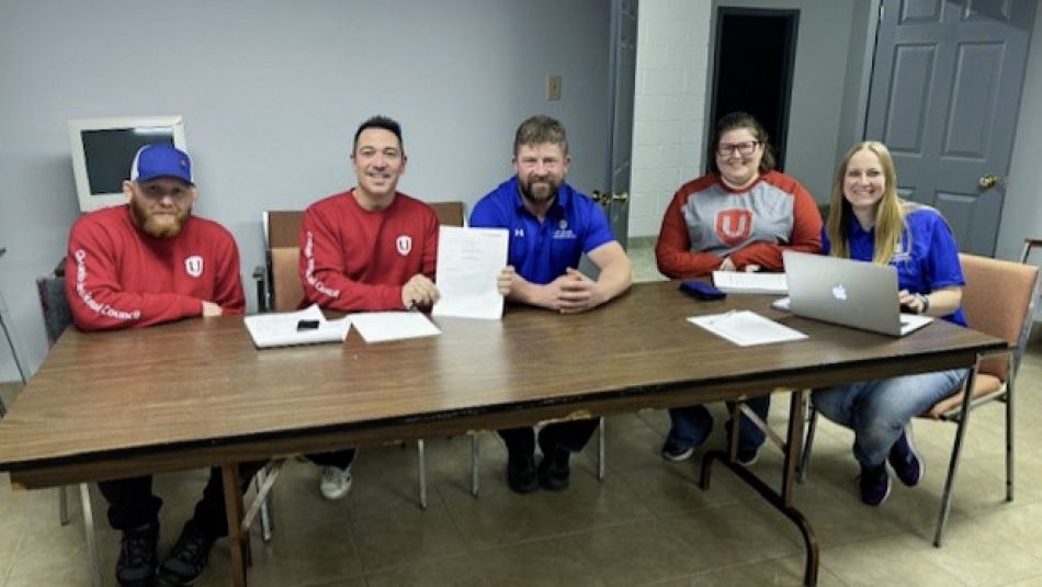 Local 848 executive committee Five people seated at a folding table. One holds up a document.