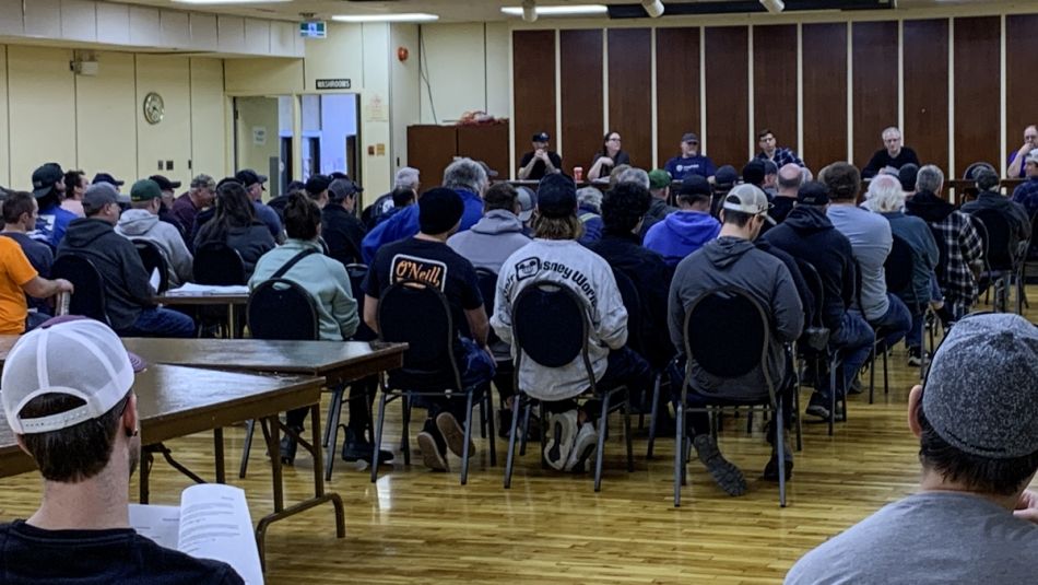 large room of union members seated with a head table at the front of the room. 