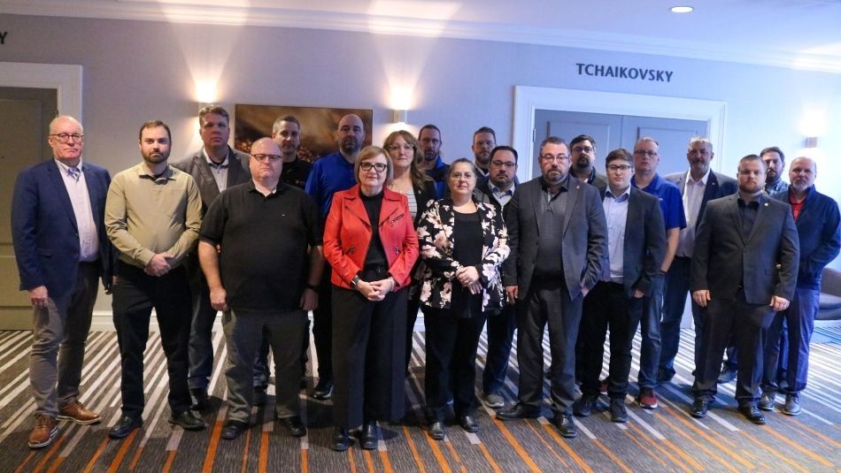 A large group standing in a hotel conference room