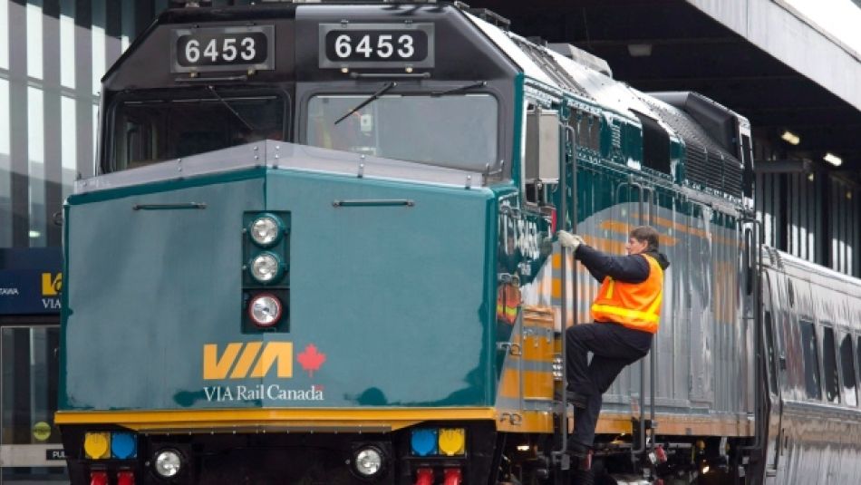 A Via Rail employee climbs aboard a locomotive at the train station in Ottawa.