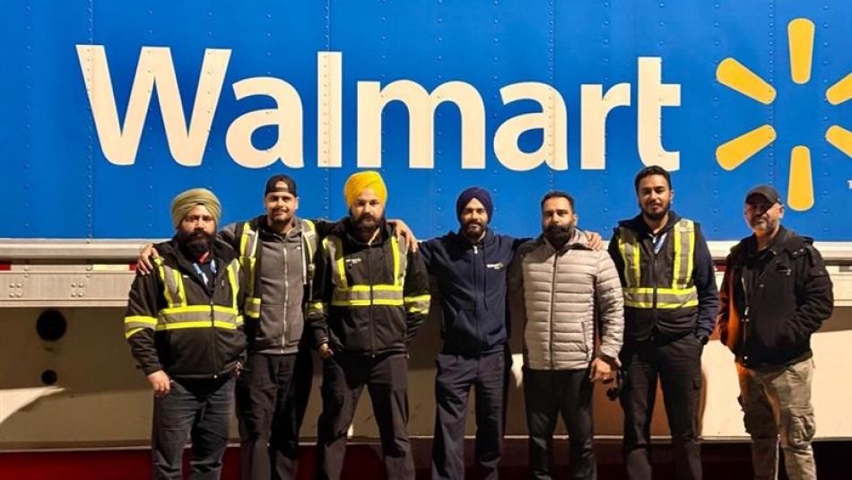 sept personnes se tenant à l'extérieur devant l'enseigne Walmart
