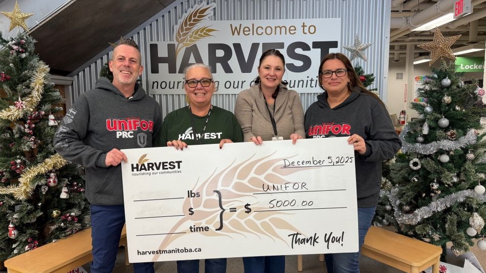 Four people holding an oversized cheque