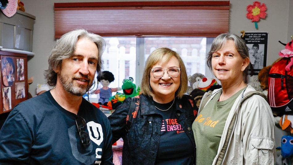 La présidente nationale Lana Payne et le directeur régional pour l'Ouest Gavin McGarrigle posent pour une photo avec un employé de refuge.