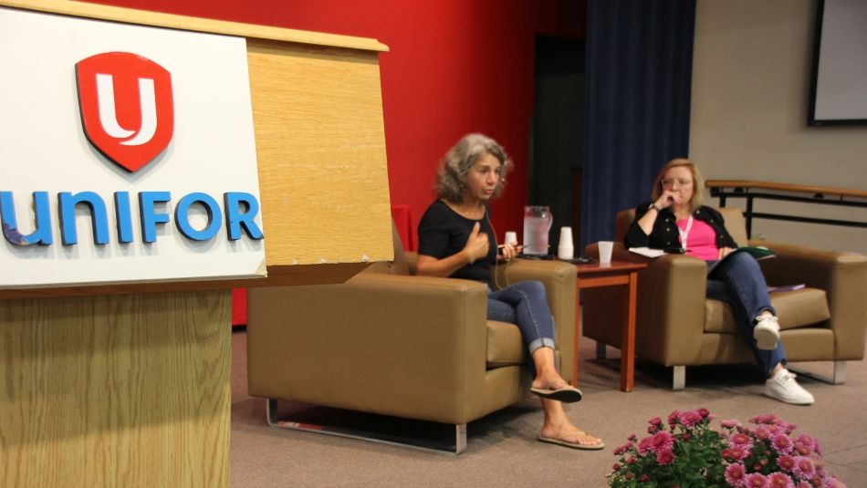 Armine Yalnizyan seated on stage next to Lana Payne with a podium in the foreground.