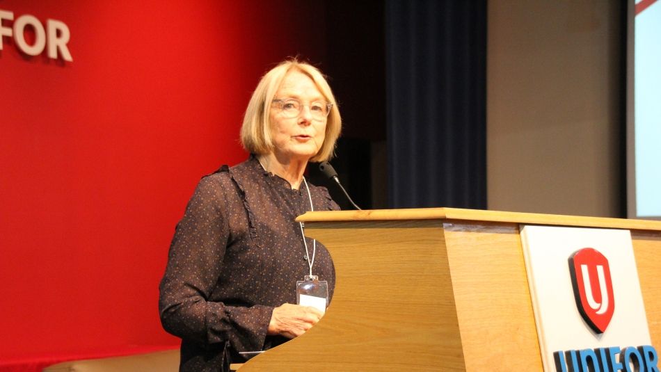 Peggy Nash standing at a podium.