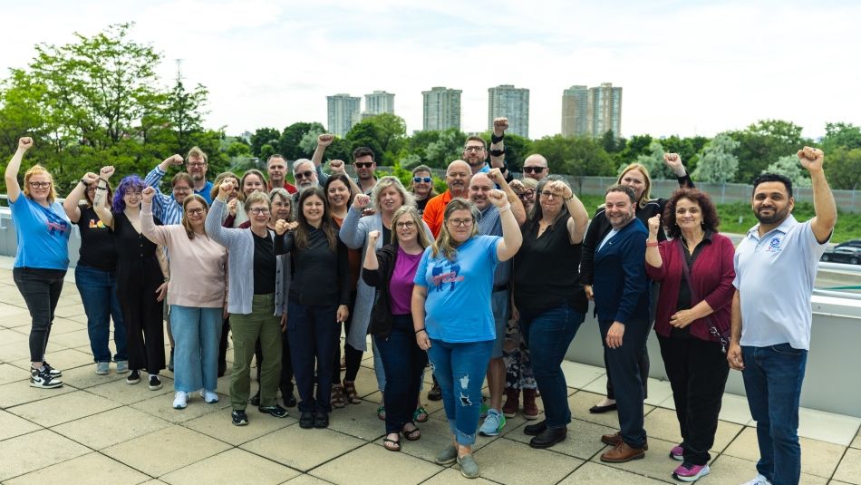 A large group posing outside with their fists raised