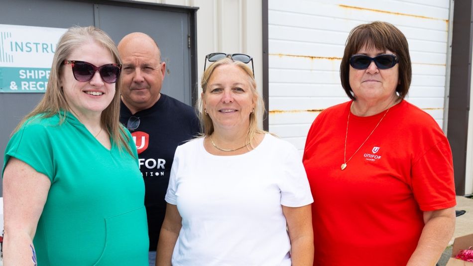 four people standing in front of a building