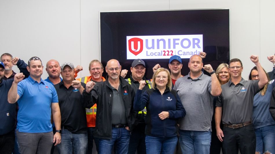 Unifor national and Local 222 leadership posing for a photo with raised fists at the GM Oshawa plant.