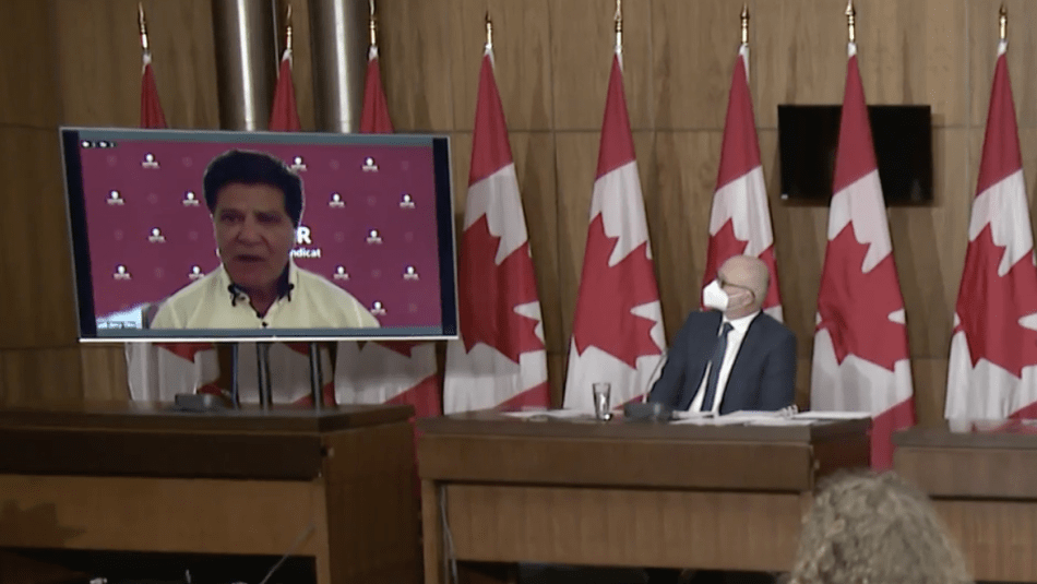 Jerry Dias appears via zoom on a screen at federal paid sick days announcement.