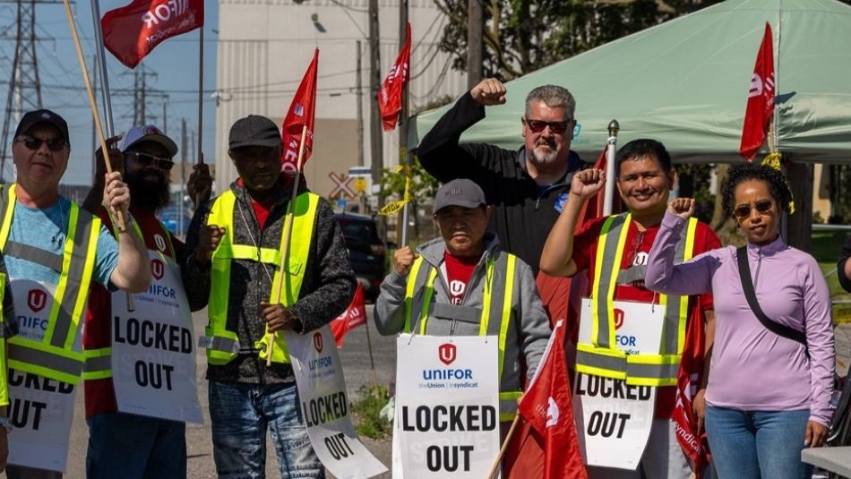 A group holding flgs and placcards wearing safety vests