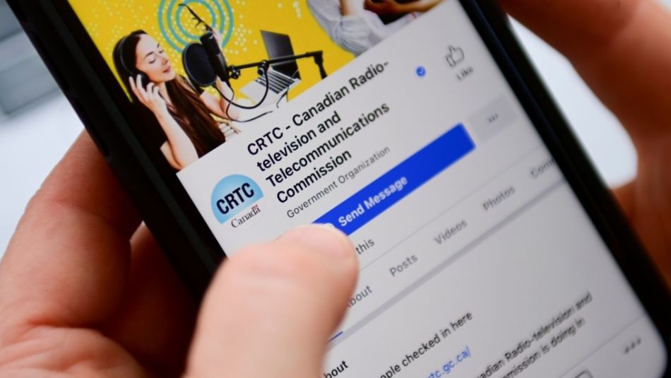 CRTC social media page on the screen of a smart phone someone is holding
