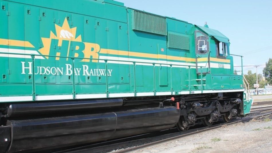 A Hudson Bay Railway train light green with yellow and white logo