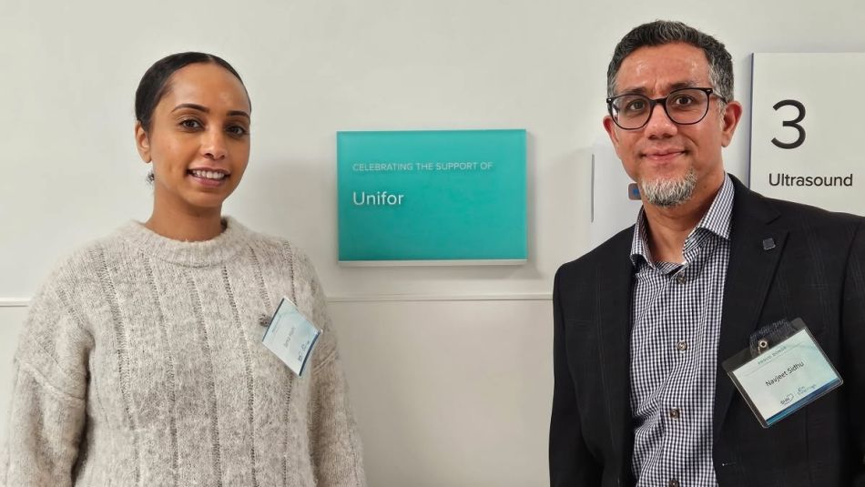 A women and a man standing beside a poster