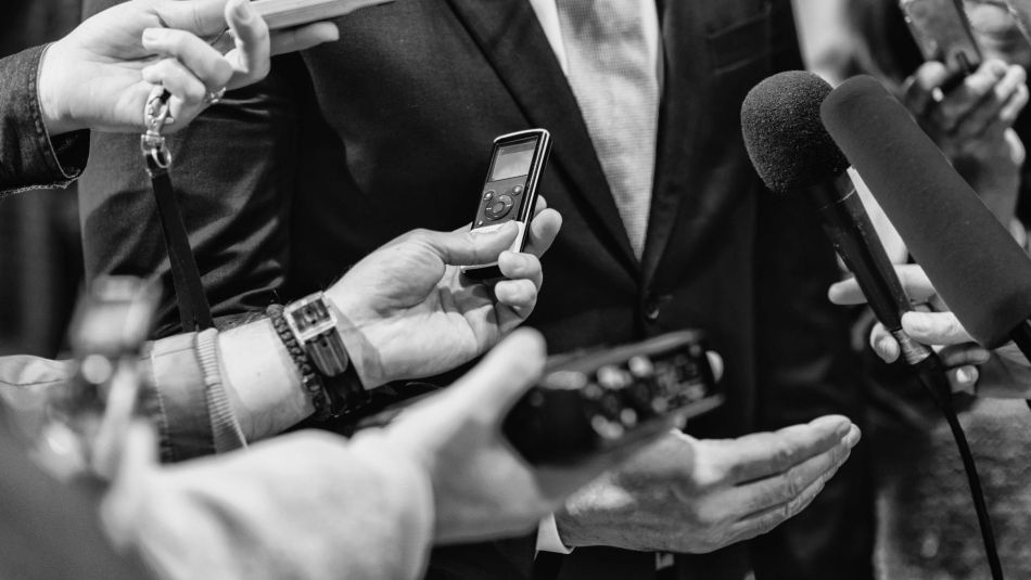 Microphones and tape recorders pointed at an interview subject.