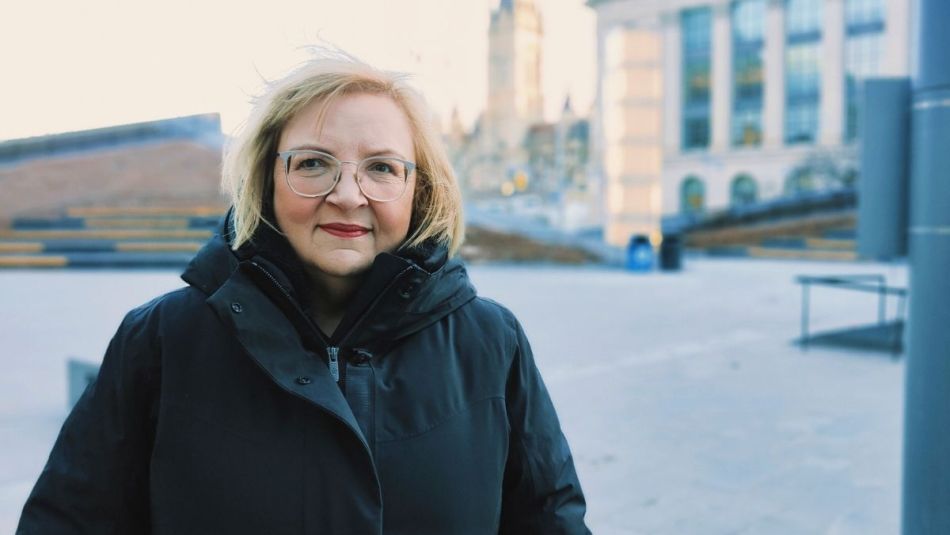 A women standing in front of parliment in the cold.