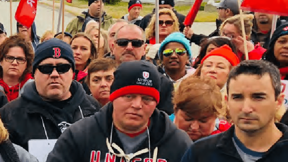 A crowd of people holding Unifor flags