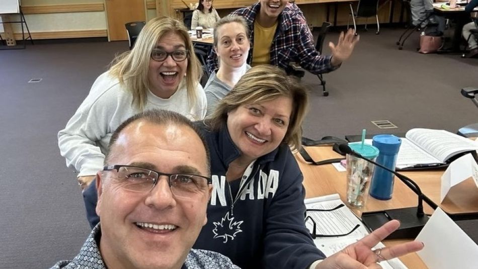 Cinq diplômés PEL d'Unifor prennent un selfie à l'intérieur d'une salle de classe du centre de formation d'Unifor.