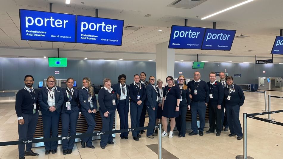A large row of ticket agents in uniform in front of a Porter ticket counter