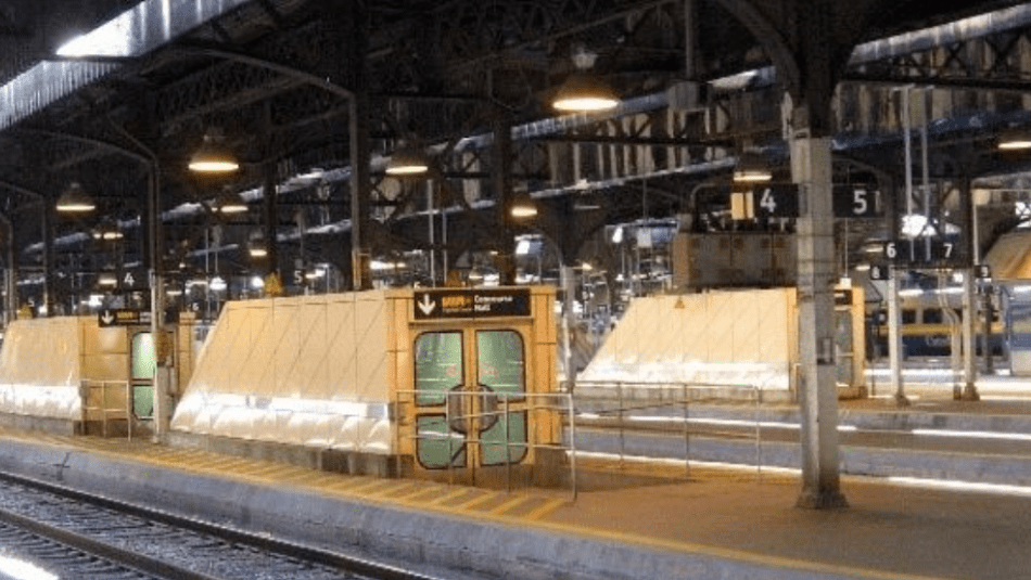 Railway train station showing empty illuminated platforms.