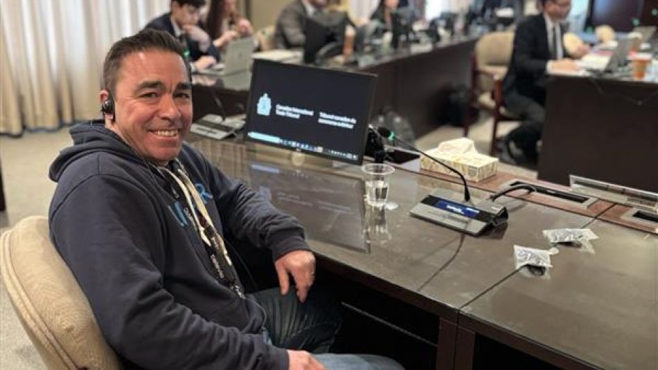 Man at table in hearing meeting room.