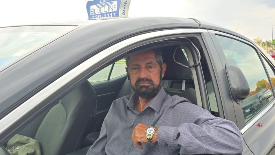 A taxi driver sitting in his car.