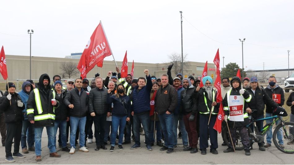 Members on the picket line holding flags and signs