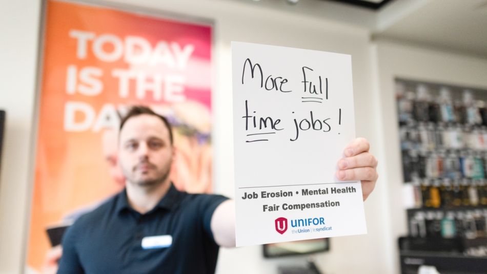 "Un homme tenant une petite pancarte indiquant "Plus d'emplois à temps plein"
