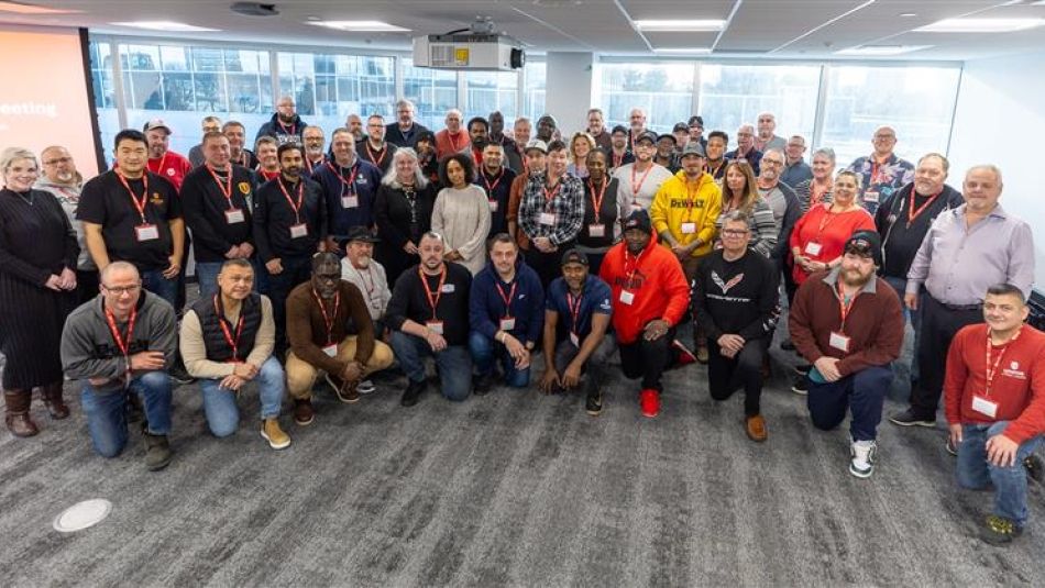 five dozen people posing indoors for a group shot.