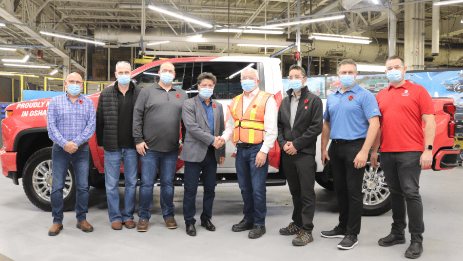 Le président national d'Unifor et les dirigeants de la section locale 222 d'Unifor posent devant le premier camion à sortir de la chaîne de montage de General Motors à Oshawa, qui a été rouverte.