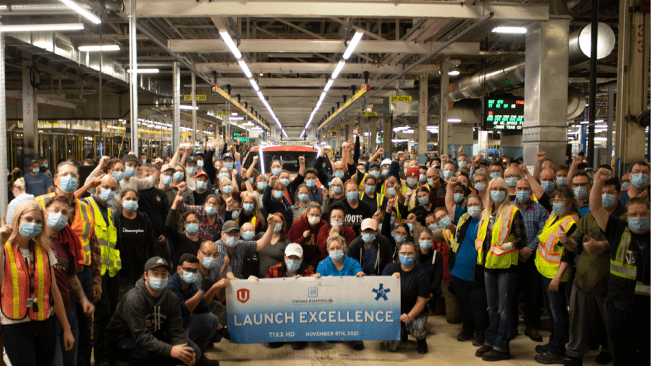 Le président national d'Unifor, Jerry Dias, est photographié avec des centaines de travailleuses et travailleurs de General Motors à Oshawa devant le premier camion à sortir de la chaîne de montage.