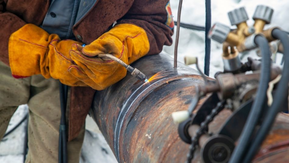 A person welding a pipe