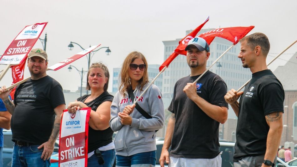 Five people holding flags on a picket line