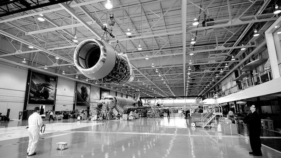 Workers at Bombardier Aerospace examine an aircraft engine nacelle