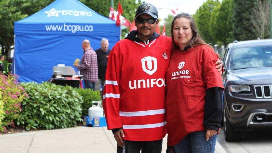 Deux membres d'Unifor, portant des chemises rouges d'Unifor, assistent à un barbecue de solidarité sur un piquet de grève du BCGEU.