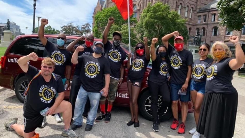 A group of people standing in front of a vehicle