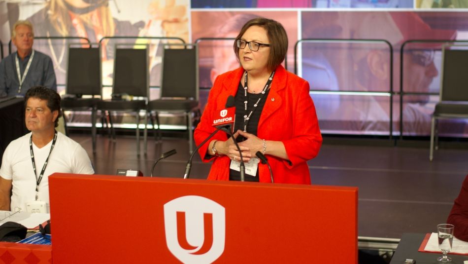 Lana Payne standing behind a microphone while addresssing delegates to Canadian Conucil.