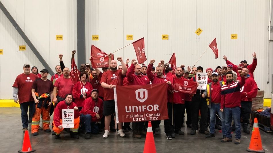 Members of Local 222 wearing matching red shirts and raising their fists in solidarity.