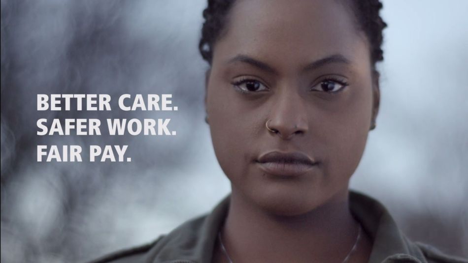 A still frame from a video shows Ayan, a Black women who works in long-term care looking to camera with the words, “Safer work. Better care. Fair pay.” on screen.