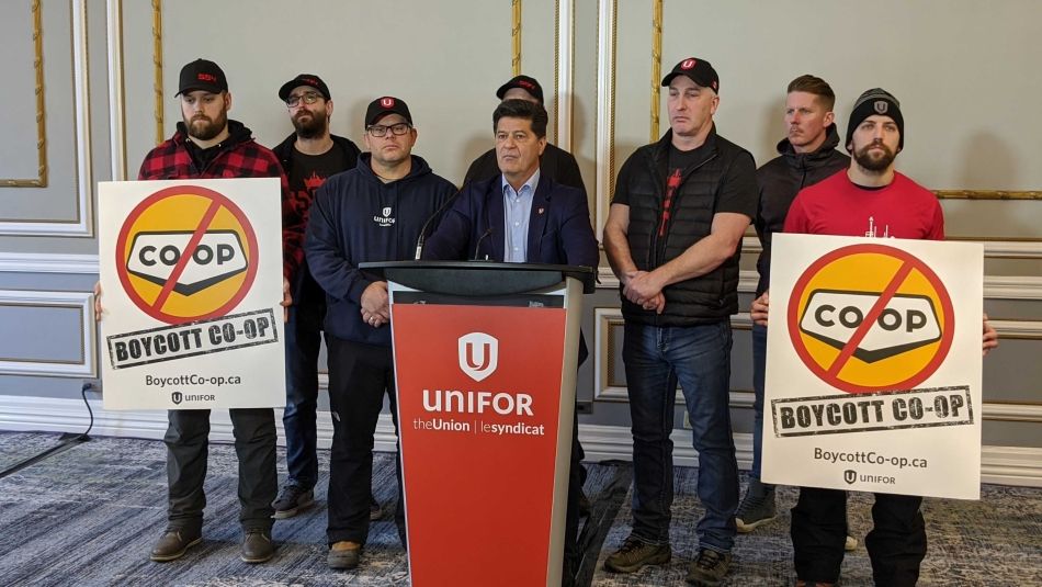 Jerry Dias at a podium with members of Unifor National and Local 594 leadership.