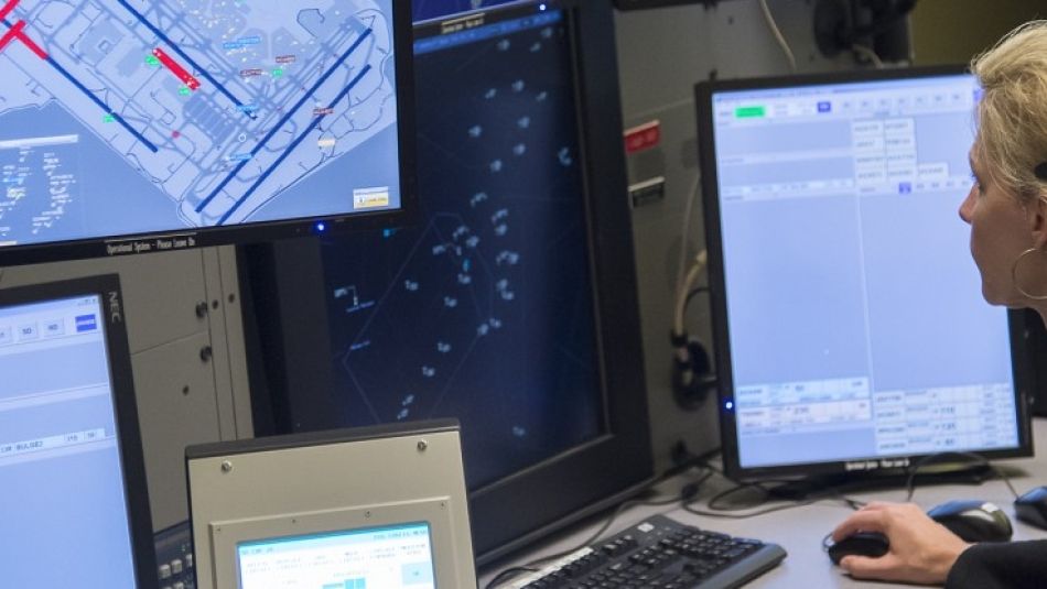 An air traffic controller monitors multiple screens.