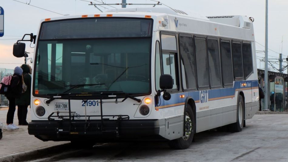 A city bus waits at a bus stop.