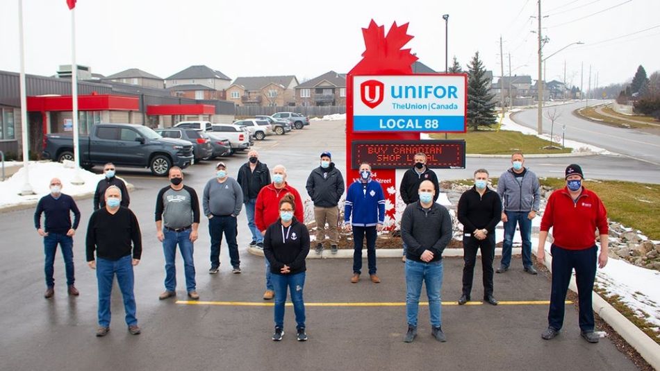 Unifor Local 88 members stand in front of their local's sign, wearing masks and respecting social distance meaures.