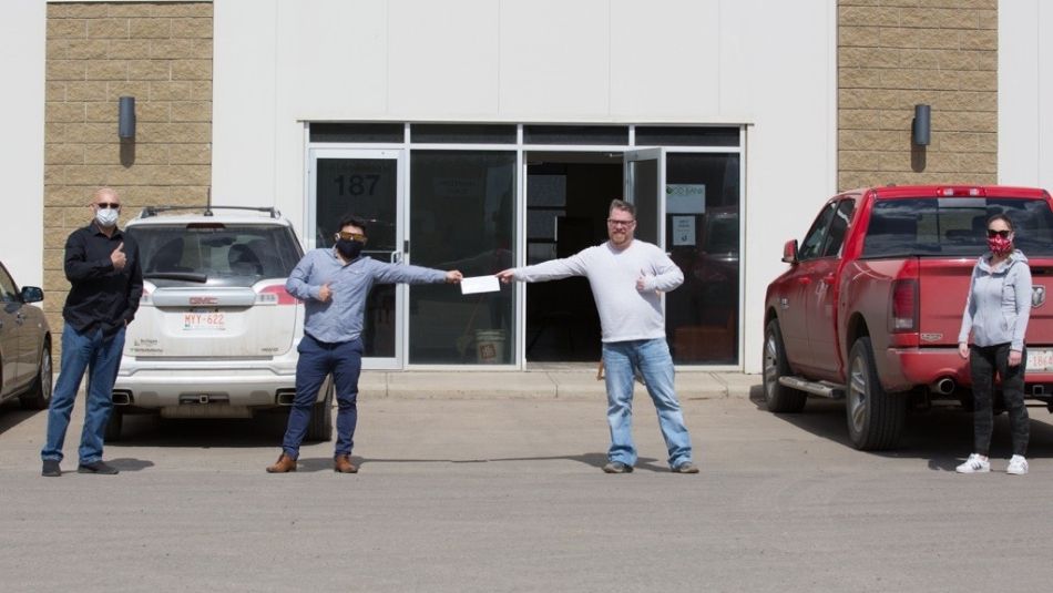 Des membres d'Unifor présentent un cheque à la banque alimentaire de Wood Buffalo.