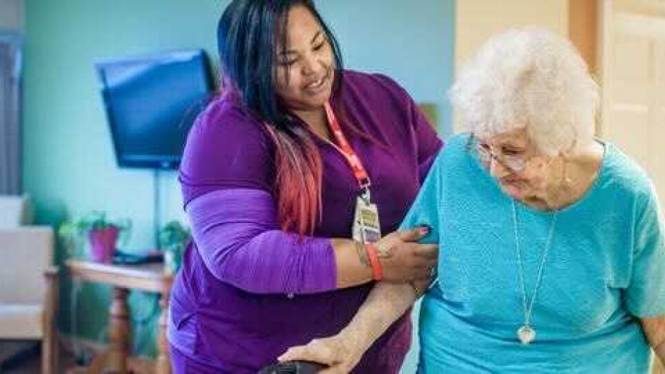 A health care worker assists a long-term care resident.